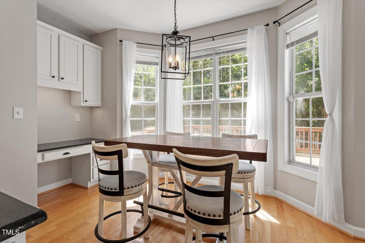 5112 Solemn Grove Road Garner, NC 27529 - Photo 24 of 56 a dining room with furniture a chandelier and wooden floor