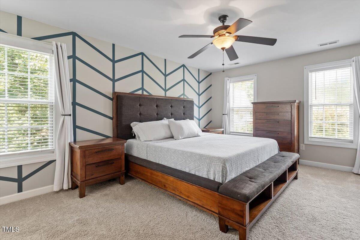 5112 Solemn Grove Road Garner, NC 27529 - Photo 26 of 56 a bedroom with a bed a chandelier and a window