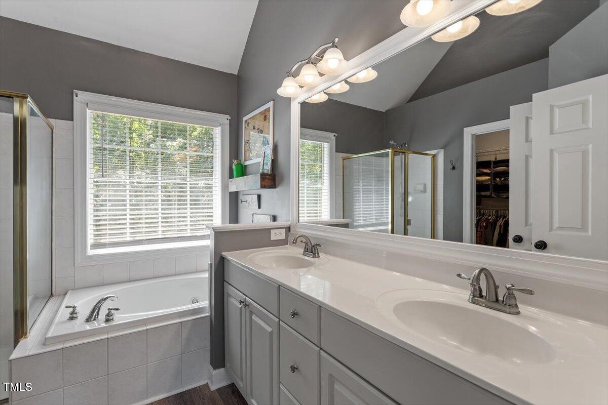 5112 Solemn Grove Road Garner, NC 27529 - Photo 28 of 56 a bathroom with a tub a sink double vanity granite and mirror