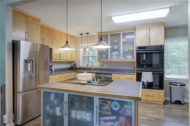 a kitchen with stainless steel appliances granite countertop a sink a stove and a refrigerator