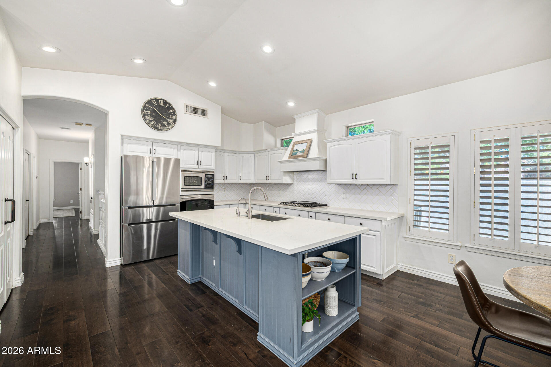 2187 East Finley Street Gilbert, AZ 85296 - Photo 27 of 89 a kitchen with a stove a refrigerator and a dining table with wooden floor