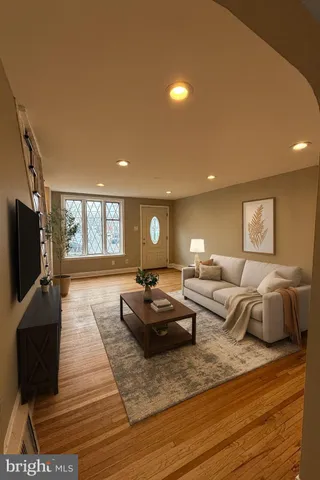 a living room with furniture a flat screen tv and a window