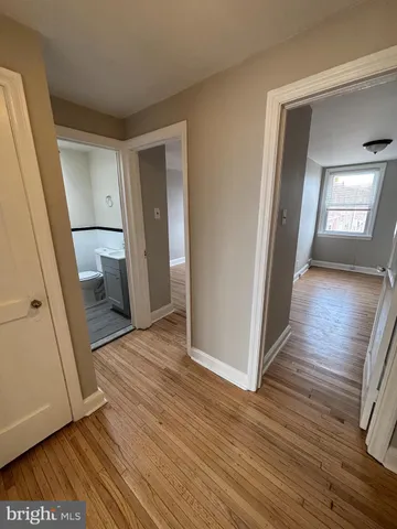 a view of a hallway with wooden floor and stairs