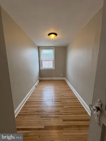a view of room with window and wooden floor