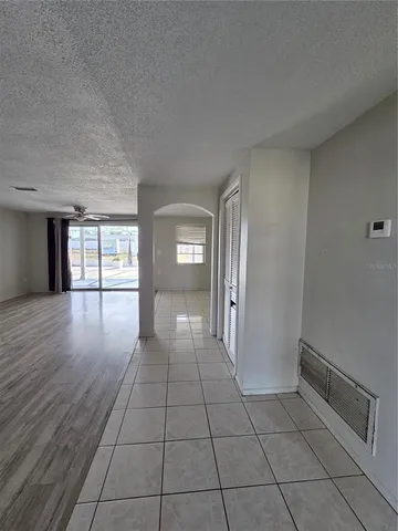 a view of empty room with window and wooden floor