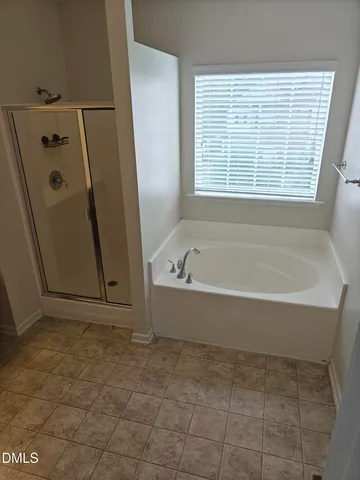 a spacious bathroom with a bathtub and a shower