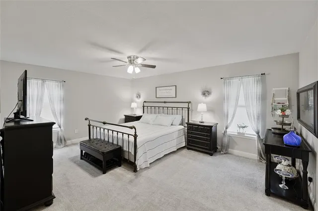 a spacious bedroom with a bed and a chandelier