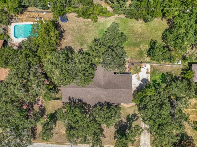 an aerial view of a house with a yard and lake view