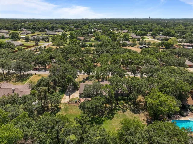 an aerial view of residential houses with outdoor space and trees