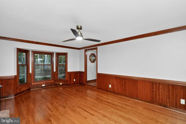a view of a livingroom with wooden floor and furniture