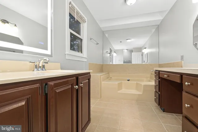 a spacious bathroom with a sink a vanity and a mirror