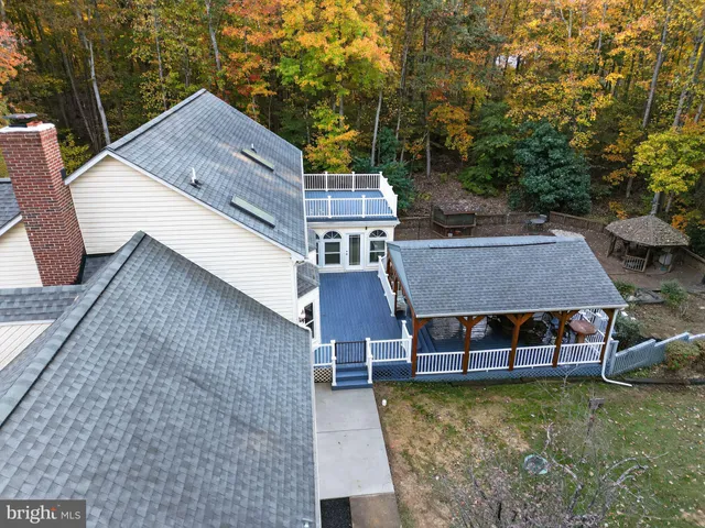aerial view of a house with a yard patio and deck