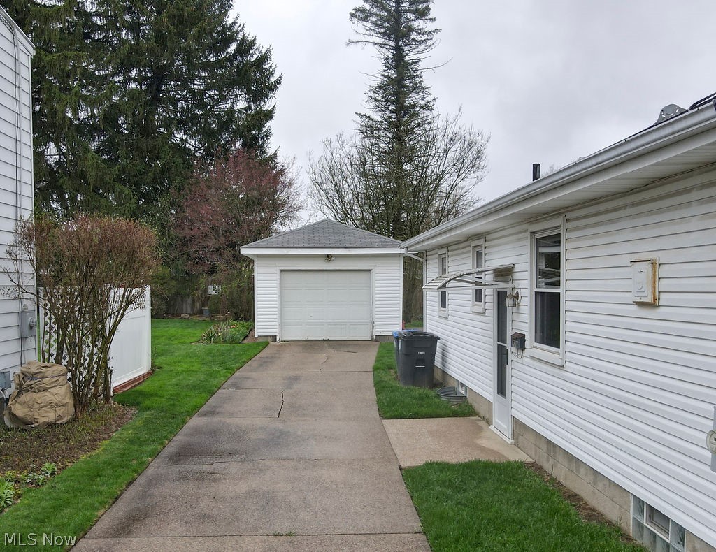 770 Yerrick Road Akron, OH 44312 - Photo 3 of 28 View of side of property featuring a garage, an outdoor structure, and a lawn