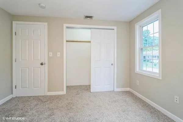 an empty room with windows and closet