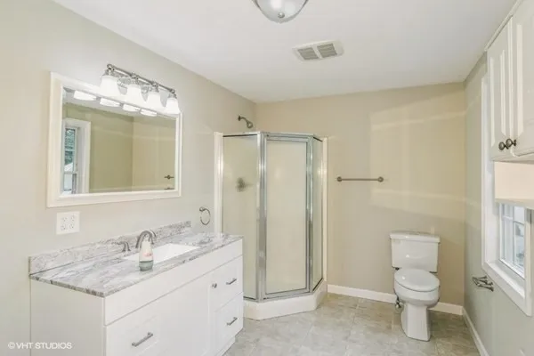 a bathroom with a granite countertop sink toilet and shower
