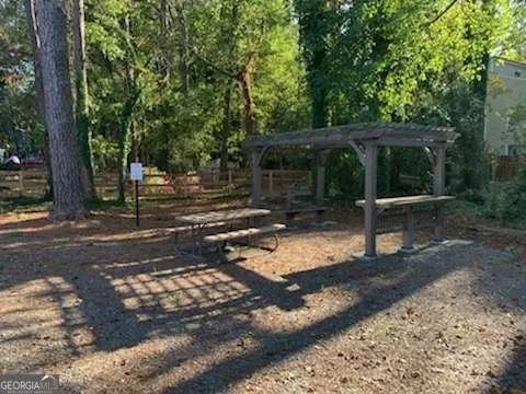 a view of a backyard with wooden fence and a large tree