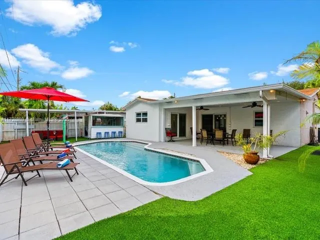 a view of a house with backyard sitting area and swimming pool