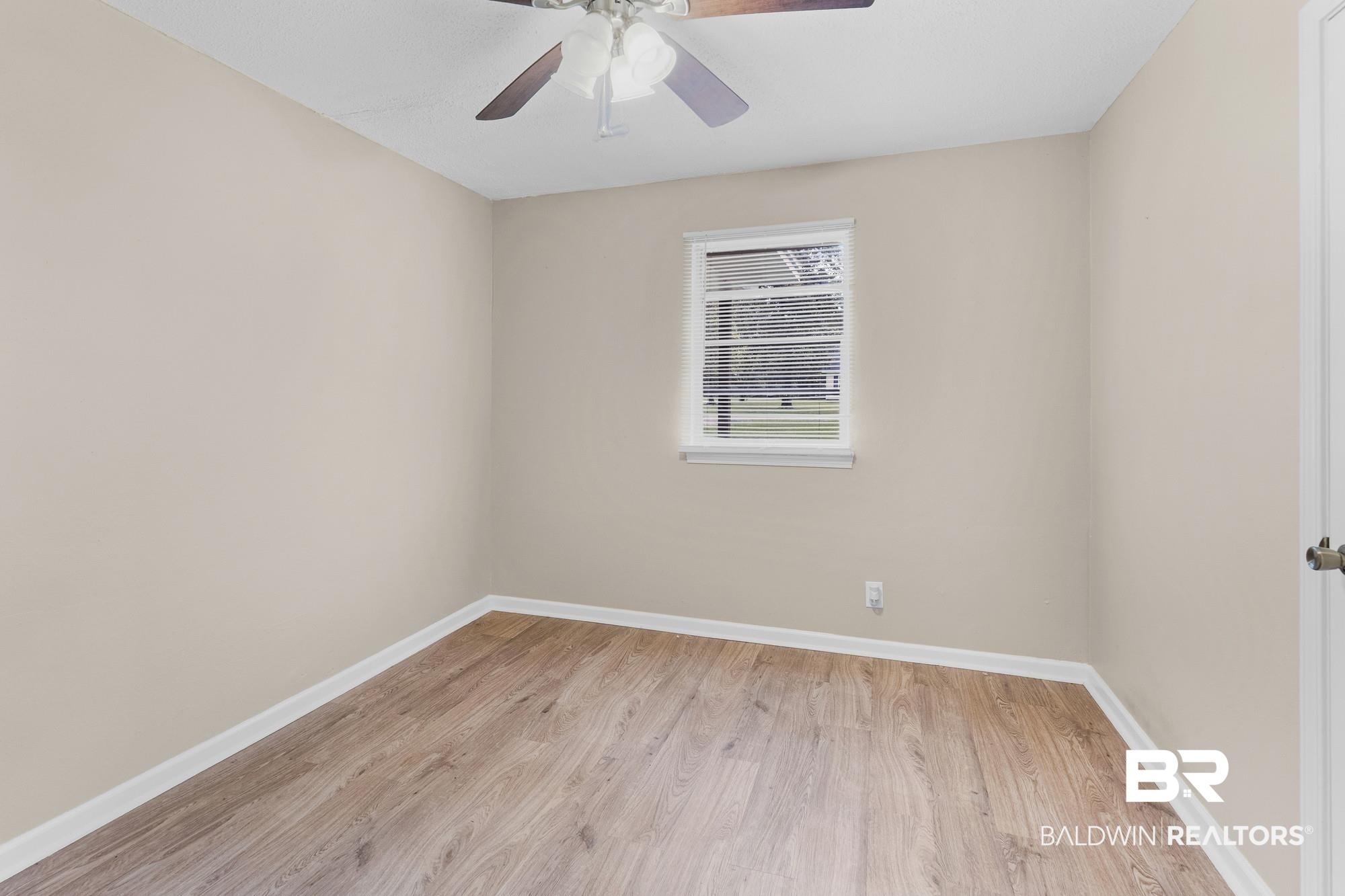 1560 Military Road Mount Vernon, AL 36560 - Photo 23 of 26 Neutral painted interior with wood-finish flooring, a ceiling fan, and a single window with horizontal blinds
