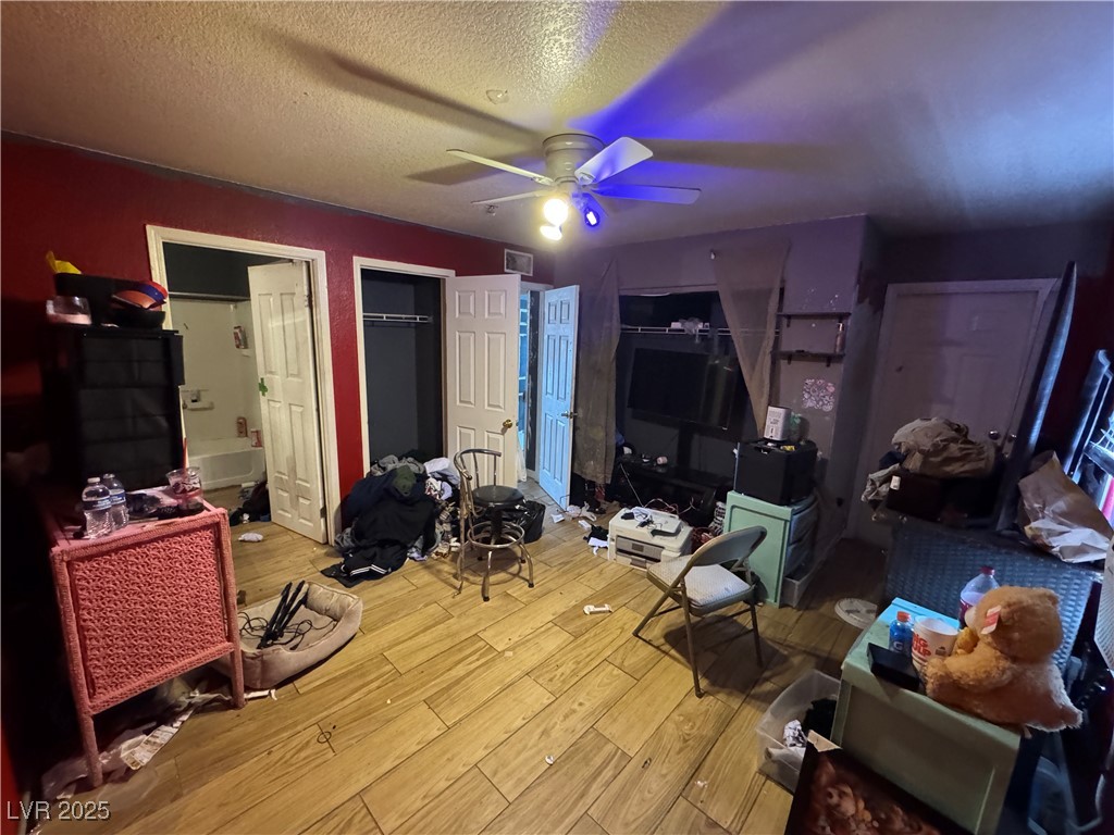 3318 North Decatur Boulevard, Unit 2057 Las Vegas, NV 89130 - Photo 14 of 18 Bedroom with light wood-style floors, a textured ceiling, and a ceiling fan