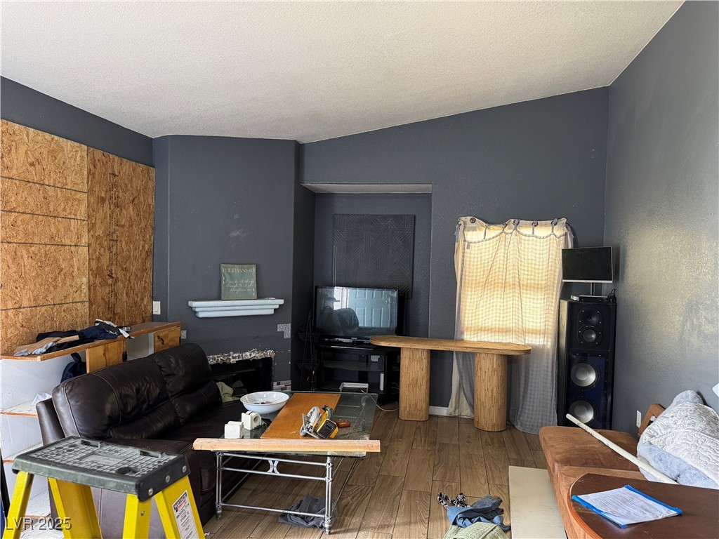 3318 North Decatur Boulevard, Unit 2057 Las Vegas, NV 89130 - Photo 3 of 18 Living area featuring wood finished floors and a textured ceiling