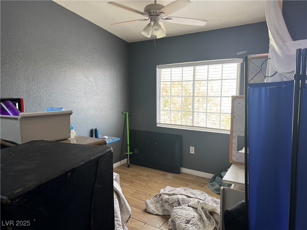 3318 North Decatur Boulevard, Unit 2057 Las Vegas, NV 89130 - Photo 4 of 18 Home office featuring light wood-type flooring, a textured wall, a textured ceiling, a ceiling fan, and water heater