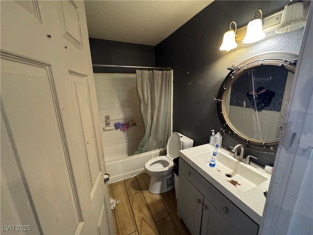3318 North Decatur Boulevard, Unit 2057 Las Vegas, NV 89130 - Photo 9 of 18 Full bathroom with shower / tub combo, dark wood finished floors, vanity, a textured wall, and a textured ceiling