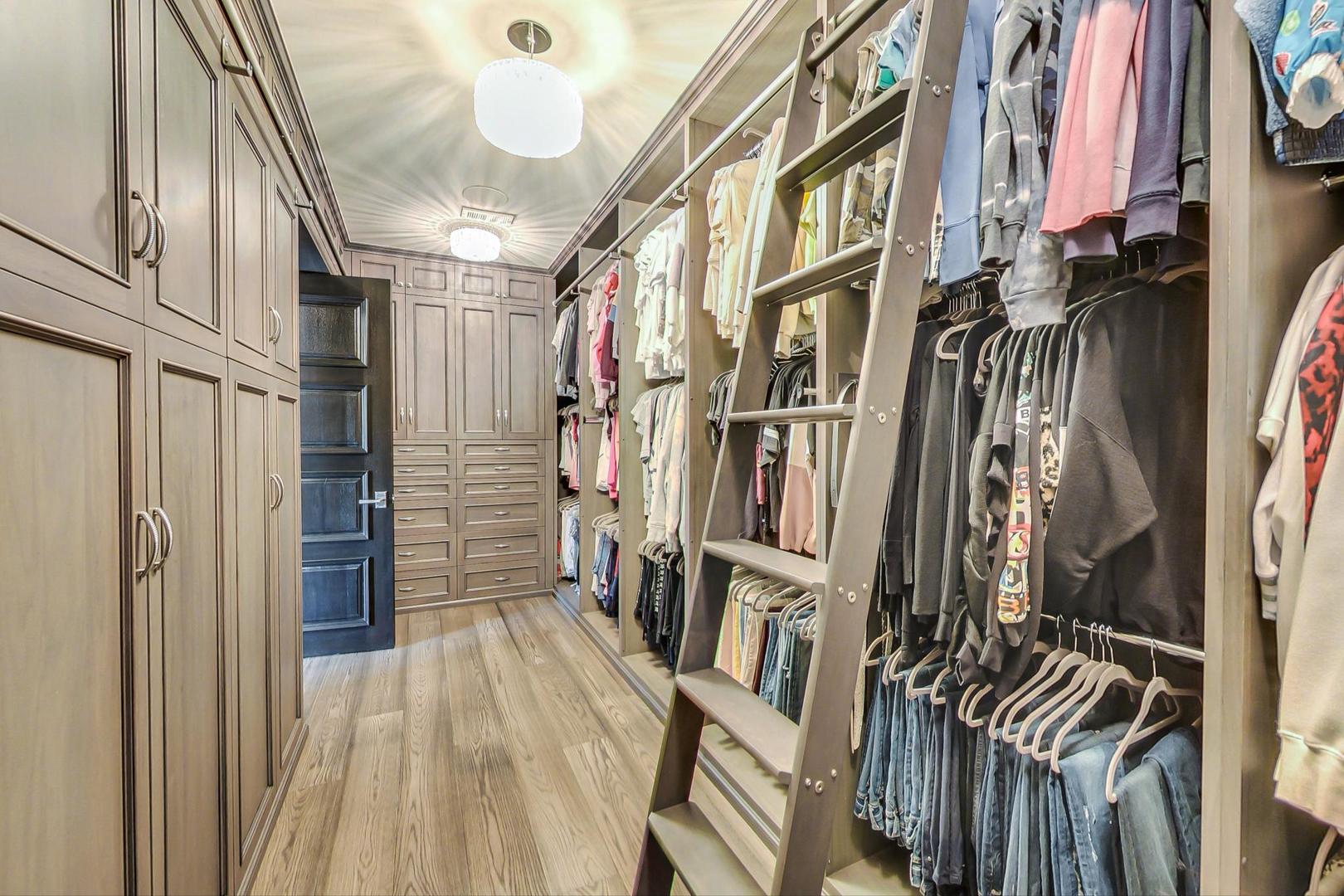 6679 Lee Court Burr Ridge, IL 60527 - Photo 40 of 98 a view of walk in closet with clothes and shoes