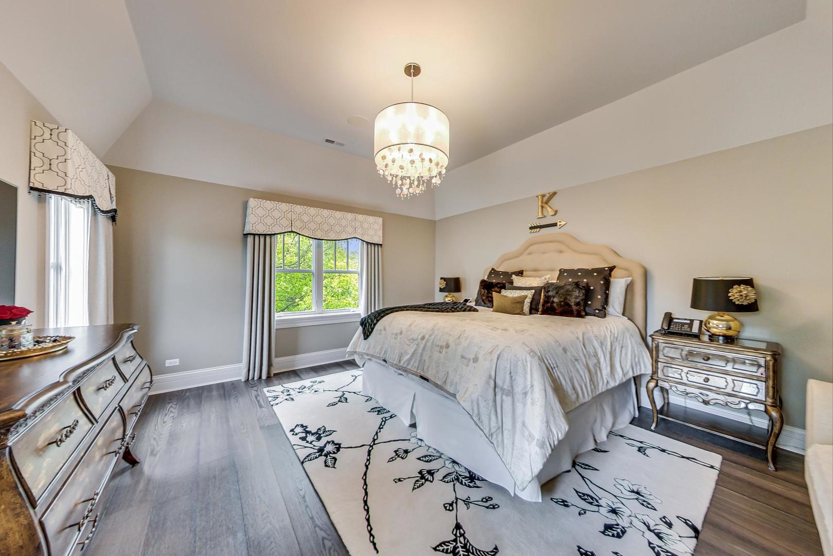 6679 Lee Court Burr Ridge, IL 60527 - Photo 46 of 98 a spacious bedroom with a bed and a chandelier