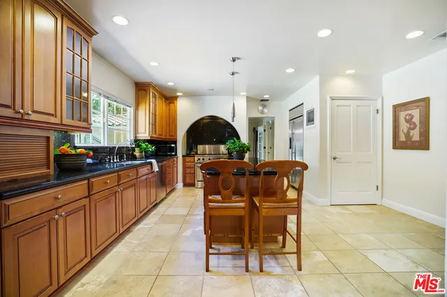a kitchen with stainless steel appliances granite countertop a stove a sink and a granite counter tops with white cabinets