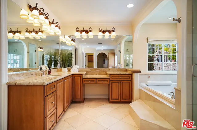 a bathroom with a granite countertop sink and a large mirror