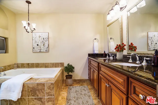 a bathroom with a bathtub shower sink and mirror
