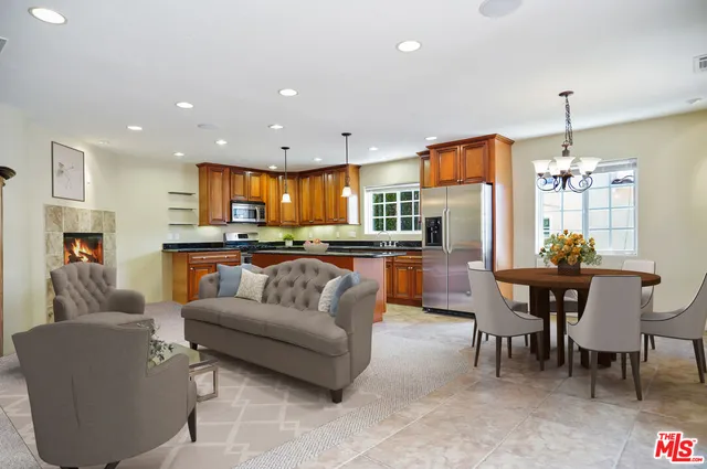 a kitchen with stainless steel appliances granite countertop a sink and a living room view