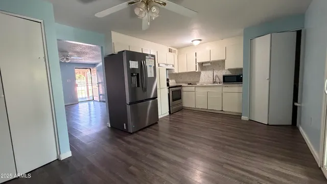 a kitchen with stainless steel appliances a refrigerator and wooden floor