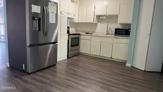 a kitchen with stainless steel appliances a refrigerator sink and cabinets
