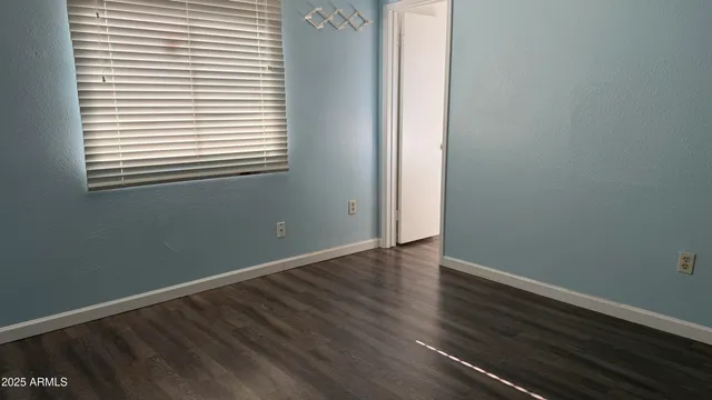 an empty room with wooden floor and a window