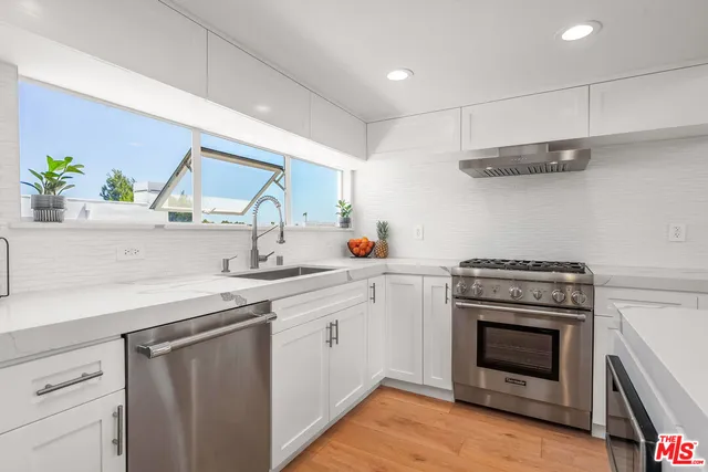a kitchen with a stove and white cabinets