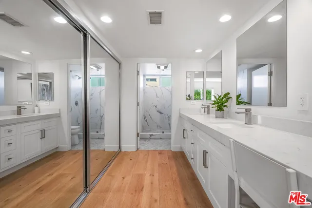 a spacious bathroom with a double vanity sink shower and a mirror