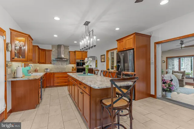 a kitchen with stainless steel appliances granite countertop table chairs sink and cabinets