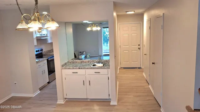 a view of a hallway with kitchen and entryway