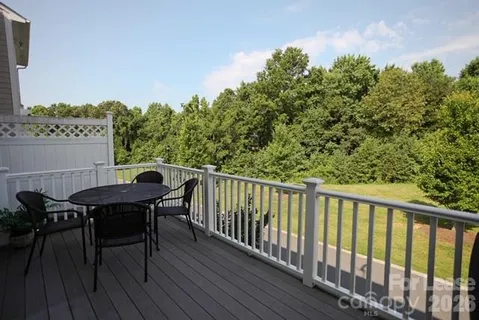 a balcony with wooden floor table and chairs