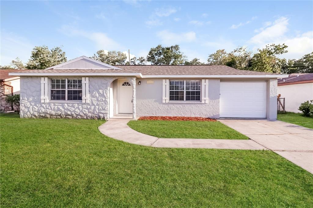 6230 Westport Drive Port Richey, FL 34668 - Photo 1 of 15 a front view of a house with a garden