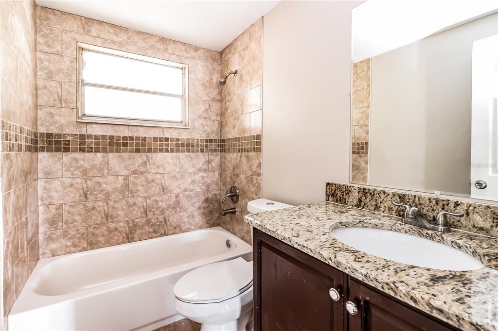 6230 Westport Drive Port Richey, FL 34668 - Photo 13 of 15 a bathroom with a granite countertop sink toilet and shower
