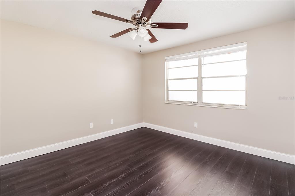 6230 Westport Drive Port Richey, FL 34668 - Photo 9 of 15 a view of an empty room with wooden floor and a window