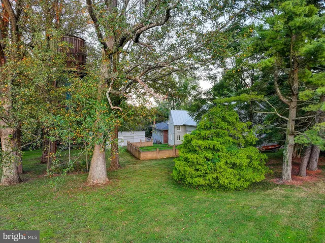 a view of a house with a big yard and large tree