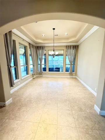 a view of an empty room with a fireplace and windows