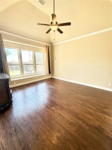 a view of an empty room with a window and wooden floor