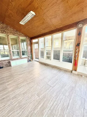 a view of an empty room with glass door and balcony