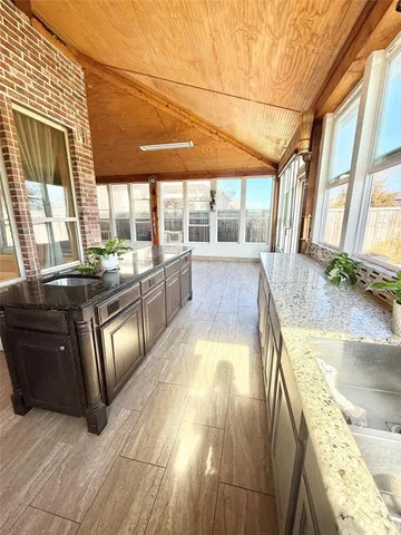 a view of a kitchen with kitchen island a large window a sink and stainless steel appliances