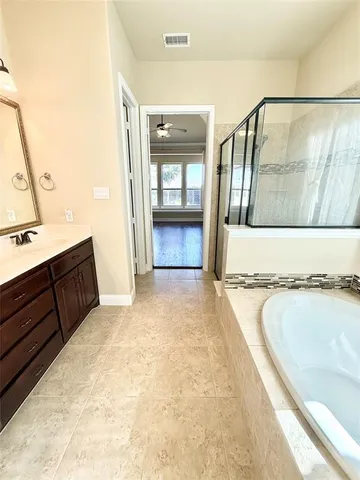 a bathroom with a tub sink and mirror