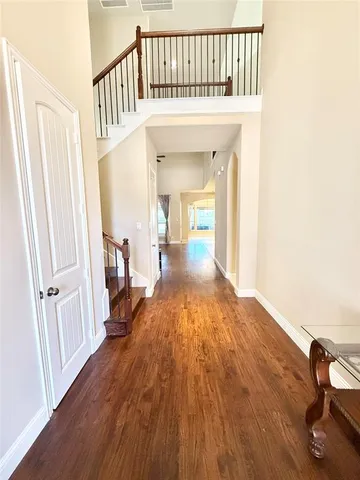 a view of a hallway with wooden floor and staircase